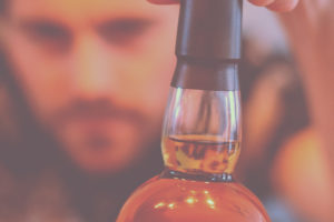 man looking at an alcohol bottle